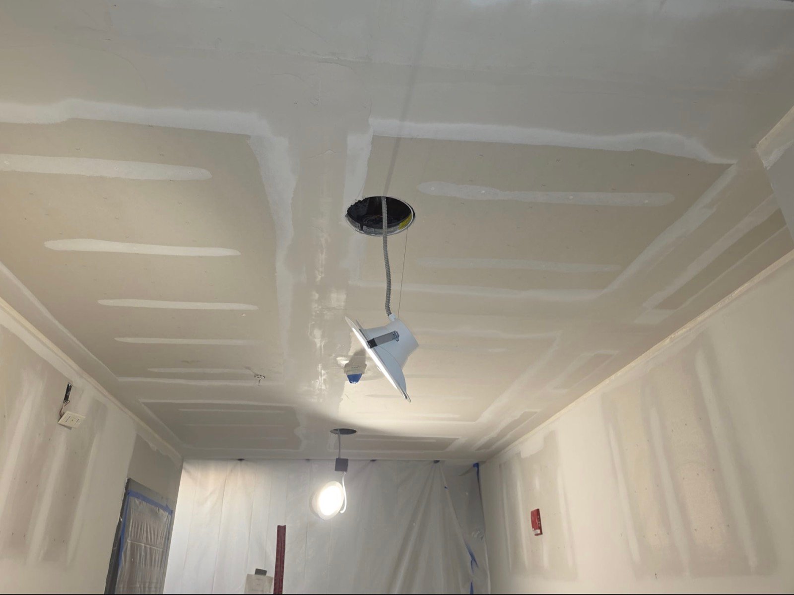 Drywall ceiling with taped and coated seams, ready for final sanding